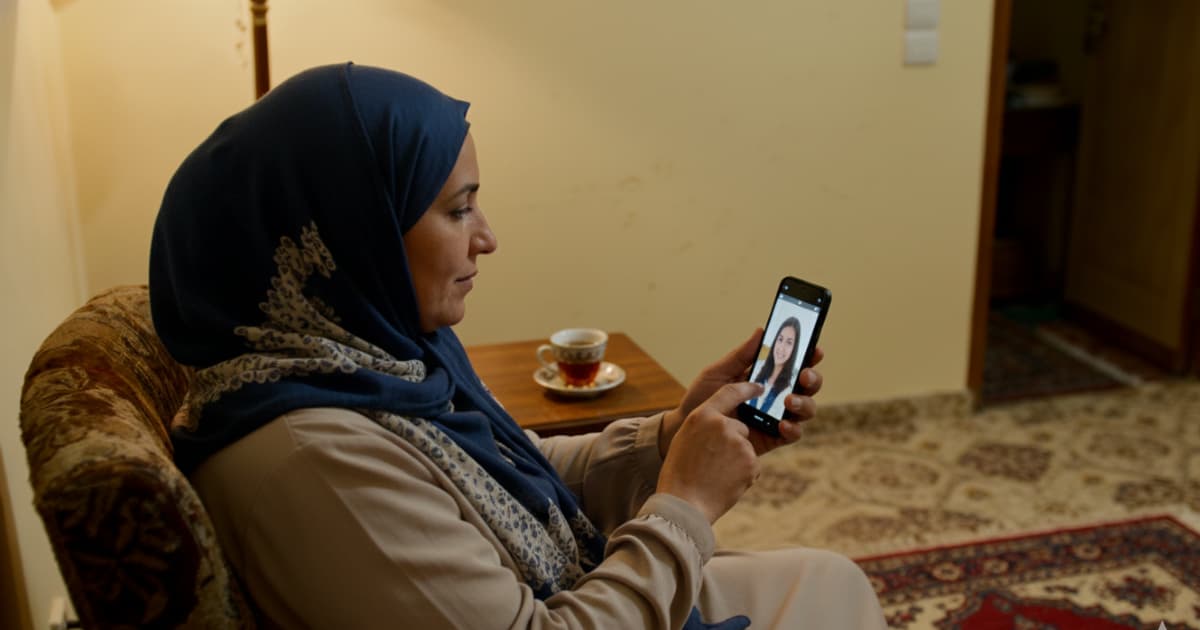 امرأة جزائرية تجري استشارة نفسية آمنة عبر الإنترنت من منزلها باستخدام هاتفها الذكي بخصوصية تامة